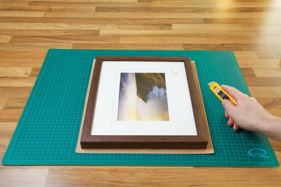 An image showing the Kraft paper being cut to the right size for the frame from John Dunne Photography by John Dunne.