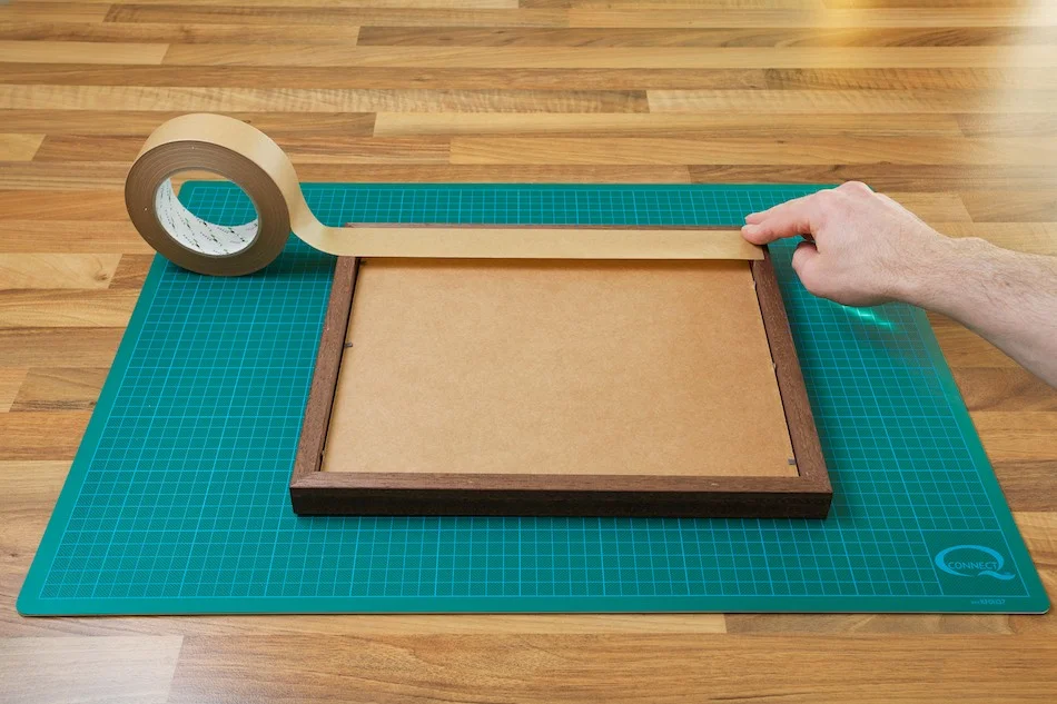 An image showing the backing board and frame being taped down from John Dunne Photography by John Dunne.